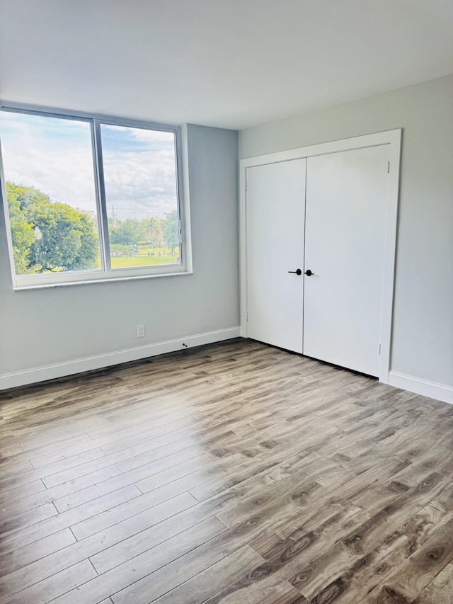 unfurnished bedroom featuring a closet and light hardwood / wood-style flooring