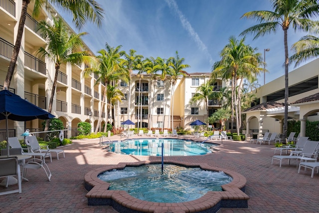 view of pool featuring a community hot tub and a patio area