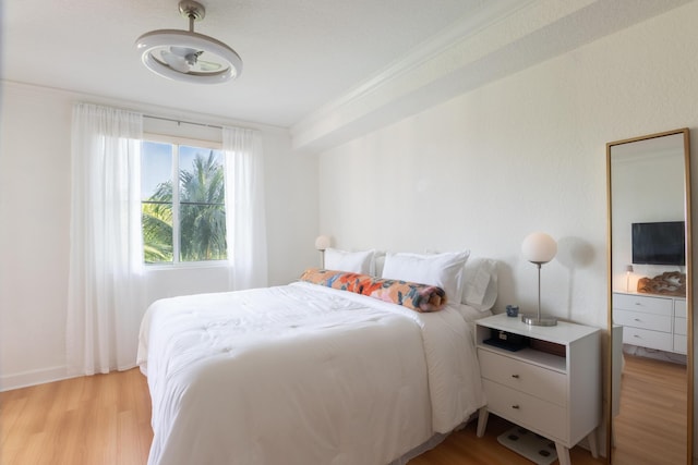 bedroom featuring crown molding and light hardwood / wood-style floors