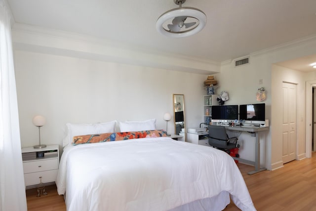 bedroom featuring crown molding and light hardwood / wood-style floors