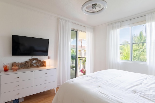 bedroom with multiple windows, ornamental molding, access to exterior, and light hardwood / wood-style flooring