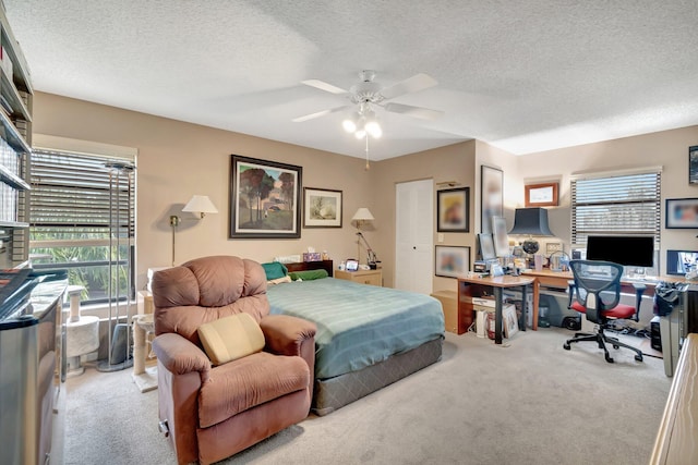 bedroom featuring multiple windows, light carpet, and a textured ceiling