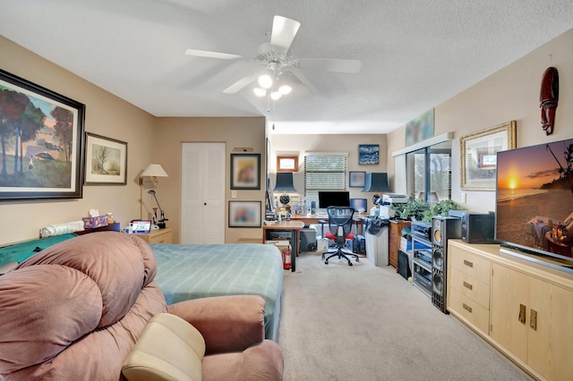 bedroom featuring ceiling fan, light colored carpet, and a textured ceiling