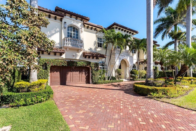 mediterranean / spanish-style home with a balcony and a garage