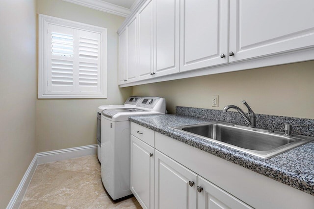 clothes washing area featuring sink, ornamental molding, washing machine and dryer, and cabinets