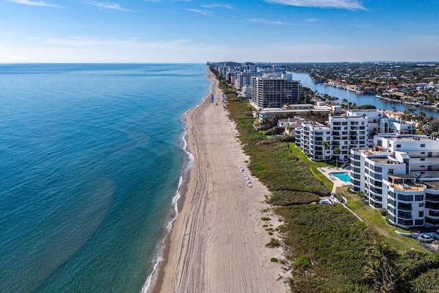 birds eye view of property with a water view and a beach view