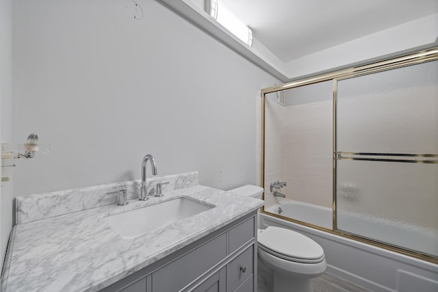 full bathroom with vanity, toilet, and combined bath / shower with glass door