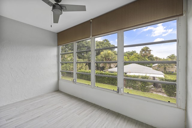 unfurnished sunroom featuring ceiling fan