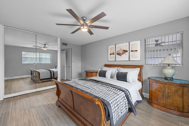 bedroom with ceiling fan, a closet, and light hardwood / wood-style flooring