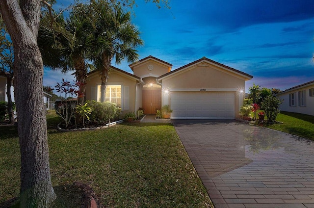 view of front of home featuring a garage and a yard