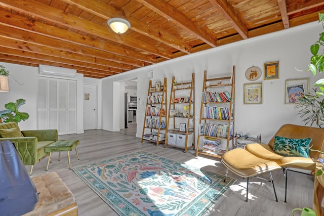 sitting room with wood ceiling, a wall unit AC, beamed ceiling, and light wood-type flooring