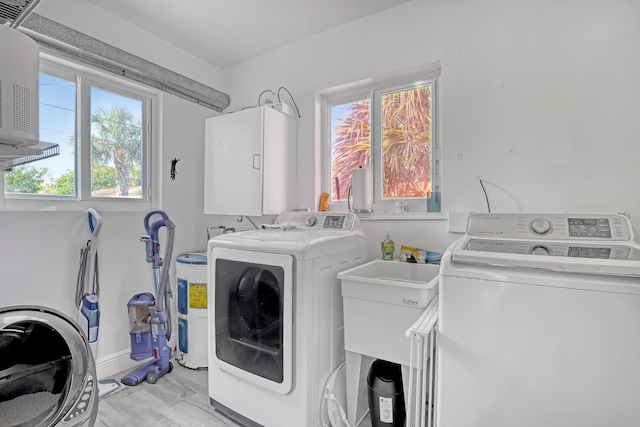 washroom with washer and dryer and light hardwood / wood-style floors