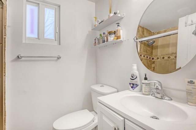 bathroom with vanity, a shower with shower door, and toilet