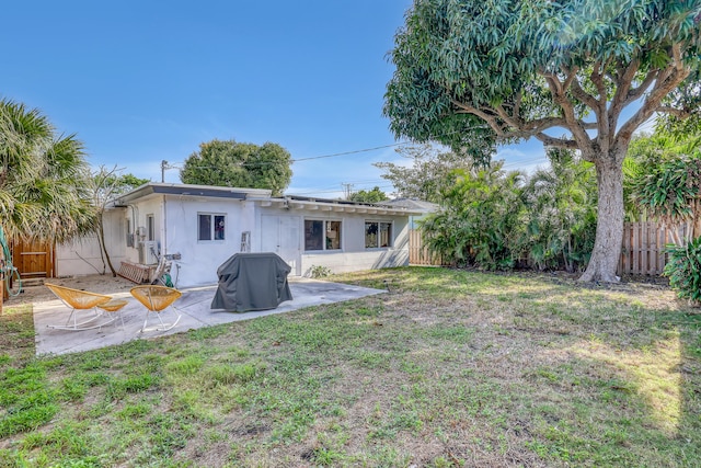 rear view of property with a patio and a yard