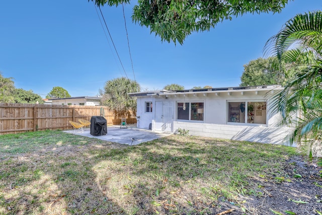 rear view of house with a yard and a patio