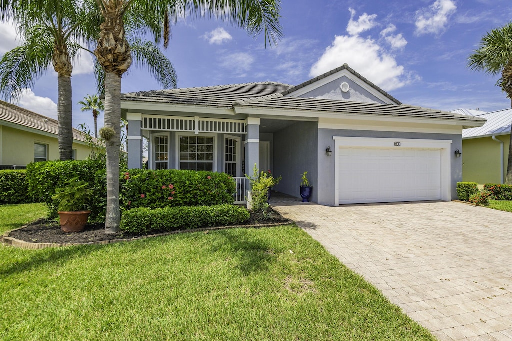 ranch-style home with a garage and a front lawn