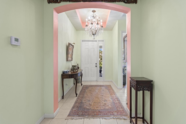 entrance foyer with light tile patterned flooring and an inviting chandelier