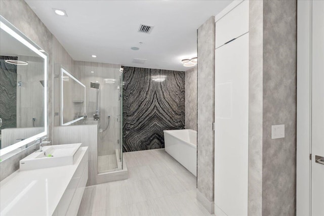 bathroom featuring vanity, plus walk in shower, and tile walls