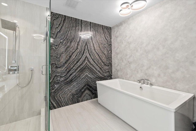 bathroom featuring plus walk in shower and tile walls