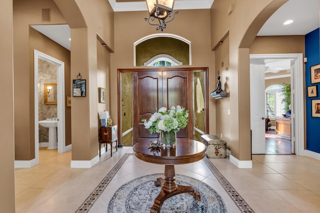 tiled foyer with ornamental molding and sink