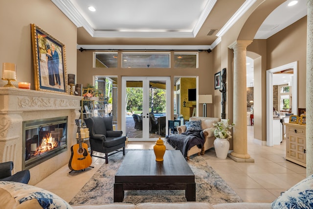 tiled living room with ornamental molding, a fireplace, decorative columns, and french doors