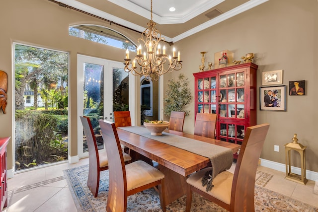 tiled dining area featuring ornamental molding, a raised ceiling, and a notable chandelier