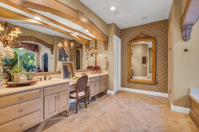 bathroom featuring vanity, a notable chandelier, and a bathtub