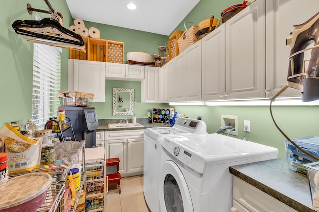 washroom featuring cabinets, light tile patterned flooring, and washer and clothes dryer