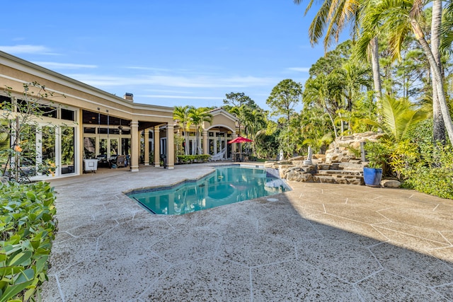 view of pool with french doors, ceiling fan, and a patio area