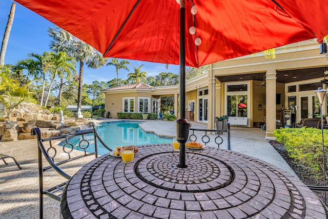 view of pool with ceiling fan and a patio