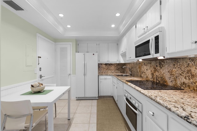 kitchen featuring a tray ceiling, visible vents, a sink, white appliances, and decorative backsplash