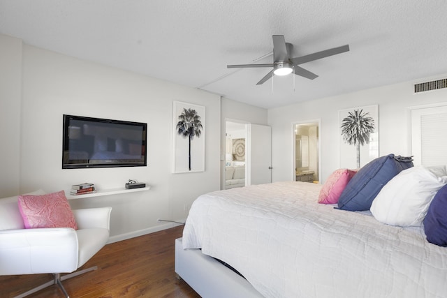 bedroom featuring ceiling fan, connected bathroom, dark hardwood / wood-style flooring, and a textured ceiling