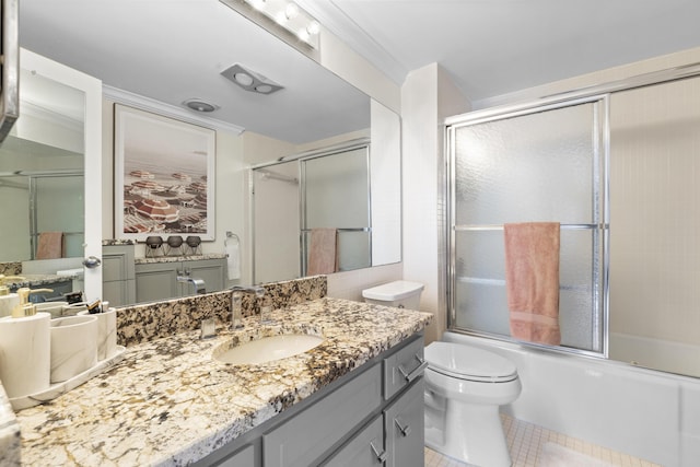 full bathroom with crown molding, bath / shower combo with glass door, vanity, tile patterned floors, and toilet