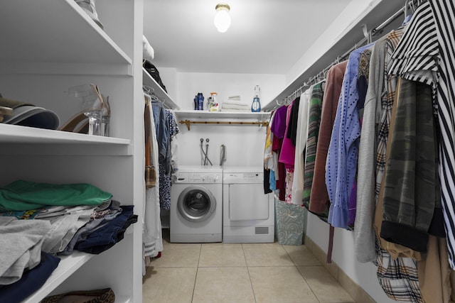 washroom with light tile patterned floors and washing machine and clothes dryer