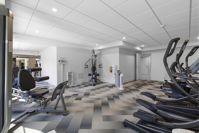 gym with baseboards, a drop ceiling, visible vents, and recessed lighting