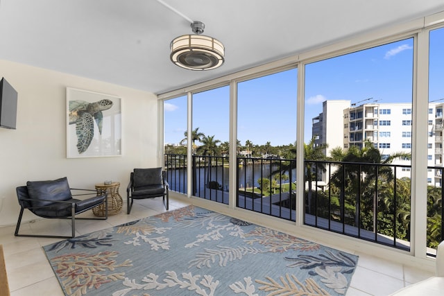 sunroom featuring a water view