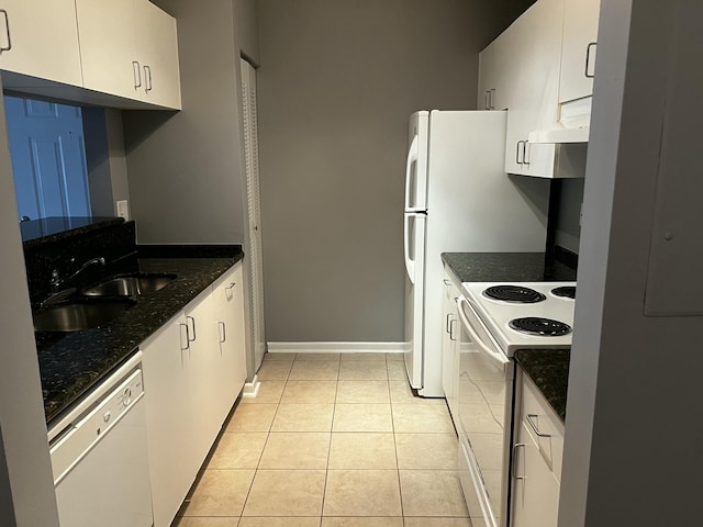 kitchen featuring white cabinetry, white appliances, dark stone counters, and light tile patterned floors