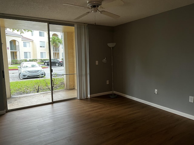 unfurnished room featuring hardwood / wood-style floors, a textured ceiling, expansive windows, and ceiling fan