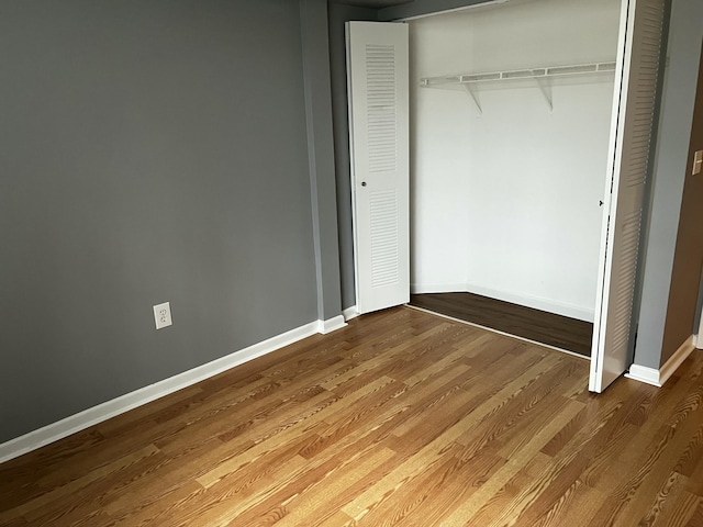 unfurnished bedroom featuring wood-type flooring and a closet