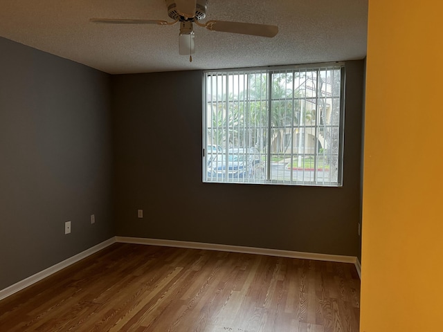 empty room featuring hardwood / wood-style flooring, ceiling fan, and a textured ceiling