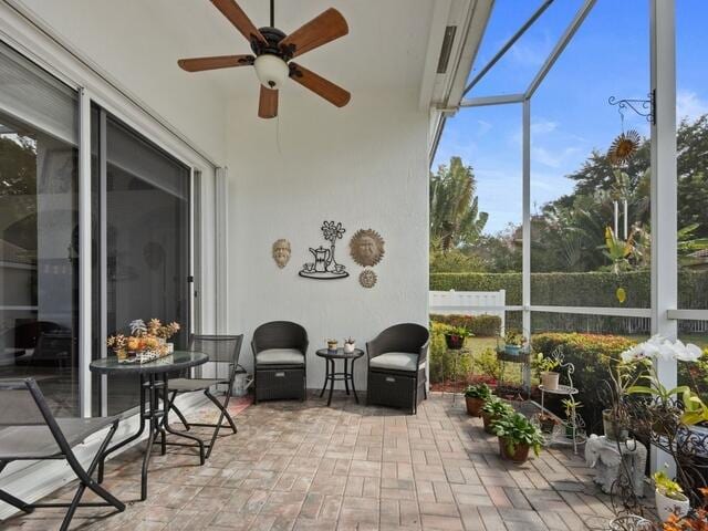 sunroom / solarium featuring ceiling fan