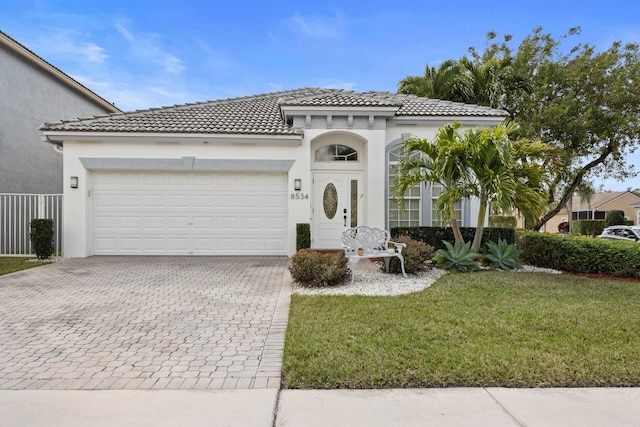 mediterranean / spanish-style house with a garage and a front lawn