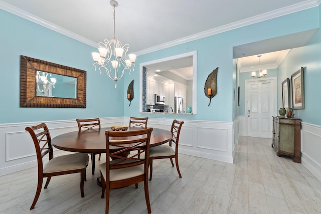 dining room featuring crown molding, light hardwood / wood-style floors, and a chandelier