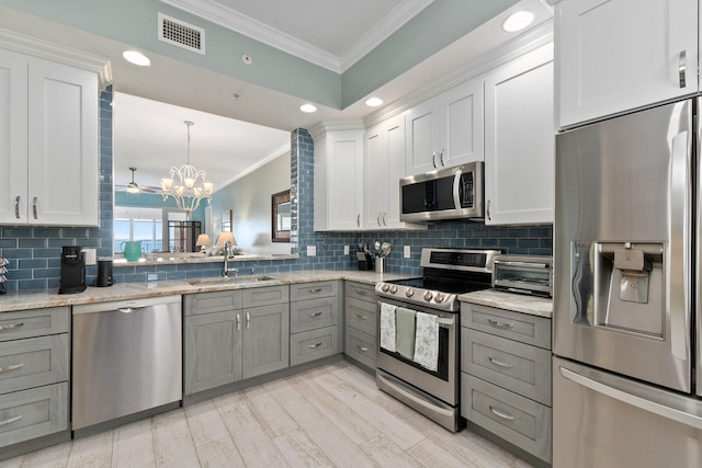 kitchen featuring white cabinetry, sink, stainless steel appliances, and gray cabinetry