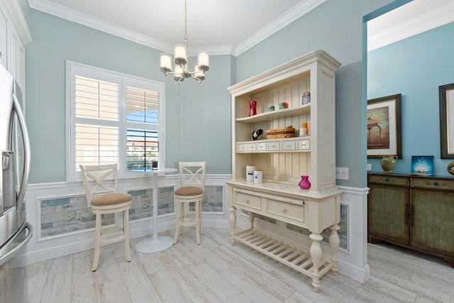 dining room featuring crown molding, a chandelier, and light wood-type flooring