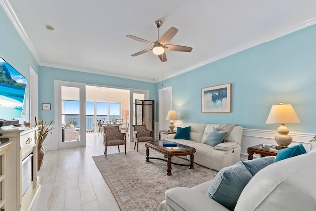 living room featuring ceiling fan, ornamental molding, and light hardwood / wood-style floors