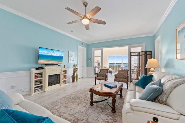 living room featuring ornamental molding, light hardwood / wood-style floors, and ceiling fan