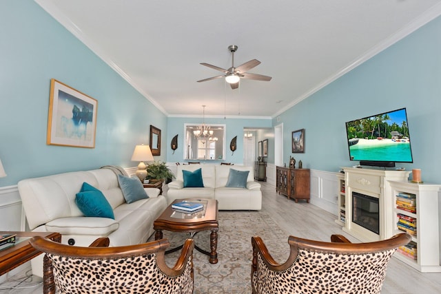 living room featuring ceiling fan with notable chandelier, light hardwood / wood-style flooring, and ornamental molding