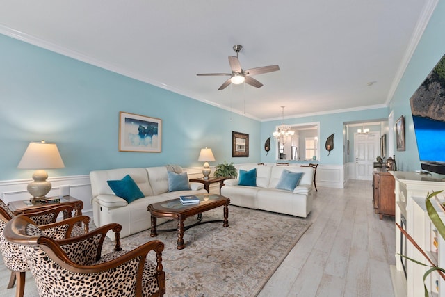 living room featuring ceiling fan with notable chandelier, ornamental molding, and light wood-type flooring