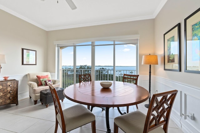 dining area with crown molding, a water view, and light tile patterned floors